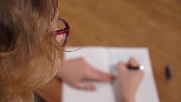 Mujer joven escribiendo texto en cuaderno blanco con pluma de tinta, borrosa — Vídeo de stock