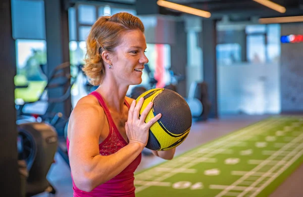 Mujer practicando con una pelota en el gimnasio — Foto de Stock