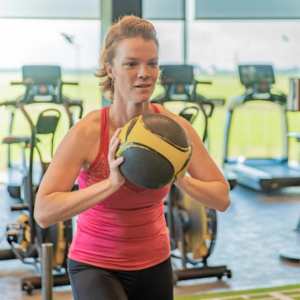 Mujer practicando con una pelota en el gimnasio — Foto de Stock