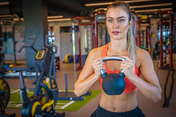 Young sporty woman strengthens with dumbbells in gym — 스톡 사진