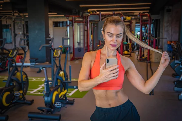 Modelo de fitness en el gimnasio tomando una foto selfie en su teléfono inteligente para compartir en la red social — Foto de Stock