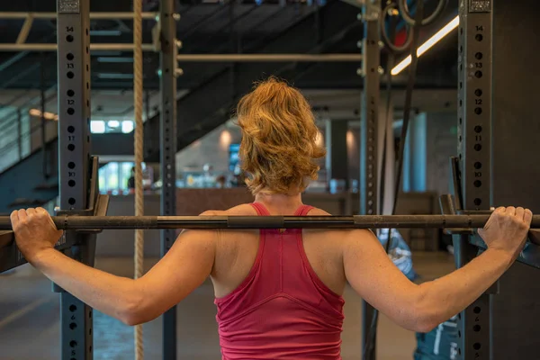 Joven mujer deportiva fortalece con mancuernas en el gimnasio — Foto de Stock