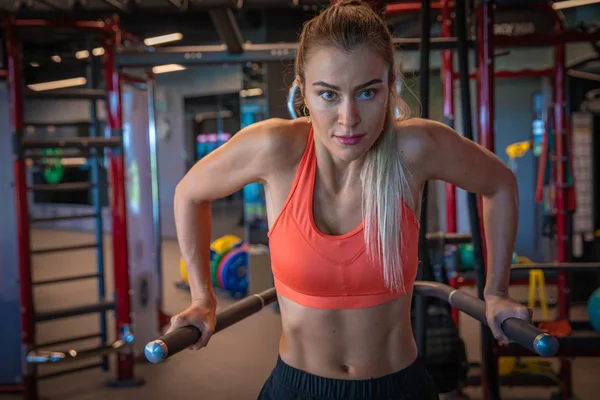 Young sporty woman strengthens with dumbbells in gym — 스톡 사진