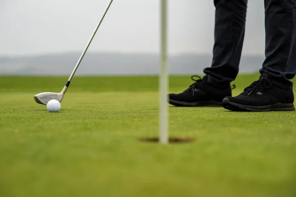 Точный удар гольфиста посылает мяч в лунку. — стоковое фото