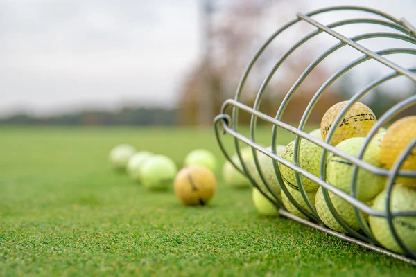 Piłeczki golfowe i kije na zielonym polu golfowym — Zdjęcie stockowe