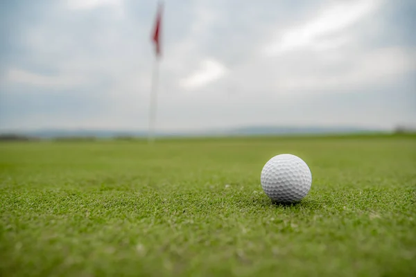 Pelota de golf en el campo de golf antes de golpear el hoyo —  Fotos de Stock