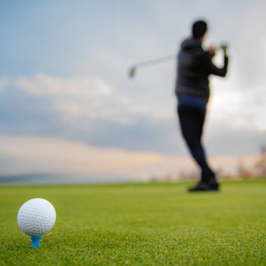 Sonbaharda turnuvada çimenli bir sahada golf toplarını vurmak.