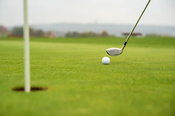 Gra w golfa na zielonym polu z piłką i kijem — Zdjęcie stockowe