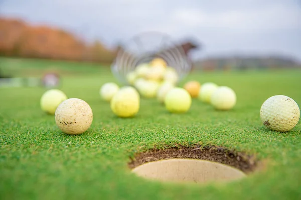 Cesta com equipamento de golfe no campo de golfe verde — Fotografia de Stock