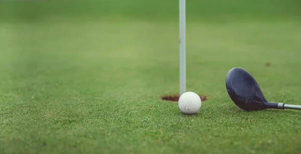 Jogo de golfe no campo verde com bola e pau — Fotografia de Stock