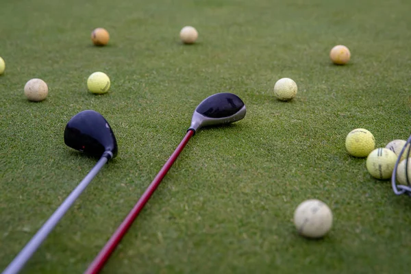 Μπάλες του γκολφ και μπαστούνια στο πράσινο γήπεδο του γκολφ — Φωτογραφία Αρχείου