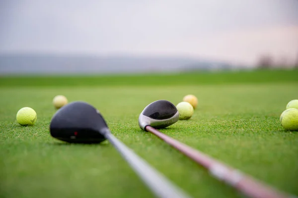 Golf balls and sticks on green golf course — 스톡 사진