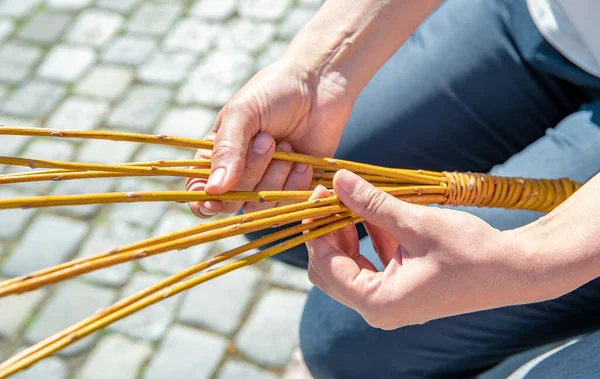 Seorang wanita menenun nya Paskah cambuk dari batang — Stok Foto
