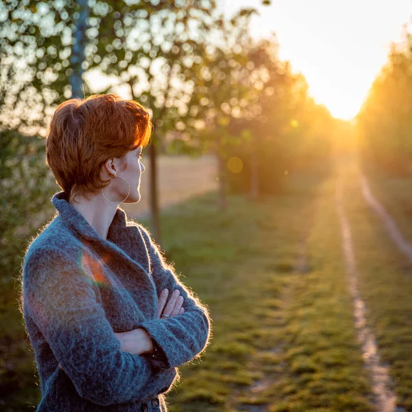 Jovem mulher no parque recebe nascer do sol — Fotografia de Stock