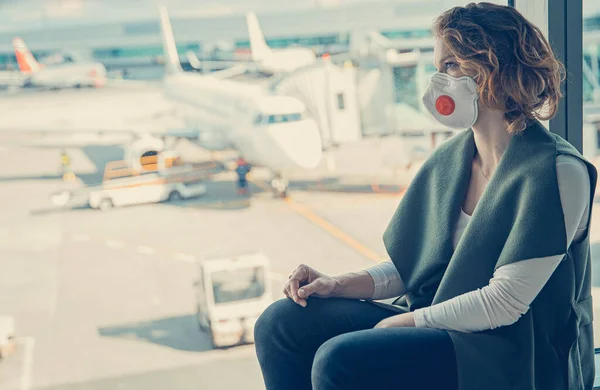 Mujer esperando el check-in en el vestíbulo del aeropuerto. El uso de respiradores para la protección contra virus — Foto de Stock