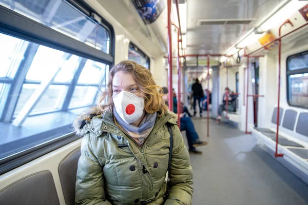 Woman in subway with medical mask on her head as a passenger. Protection against viral diseases