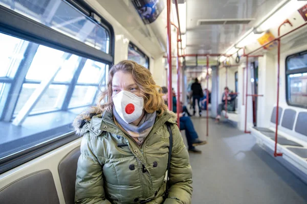 Mujer en el metro con máscara médica en la cabeza como pasajero. Protección contra las enfermedades virales —  Fotos de Stock