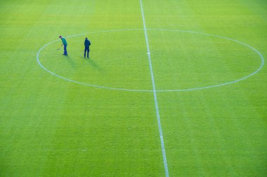 Futbol sahasının bakımı, oyundan sonra çapayı kullanarak elle çimen ayarlamaları