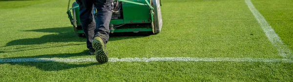 Klippa gräset innan matchen på fotbollsplanen med en traktor — Stockfoto