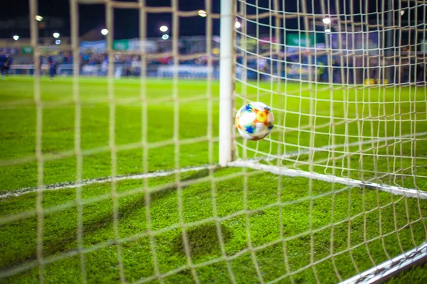 A bola voa para o portão de futebol no campo gramado verde — Fotografia de Stock