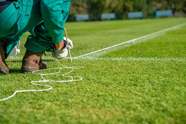 Rozciąganie liny do podszewki boiska piłkarskiego przy użyciu białej farby na trawie — Zdjęcie stockowe