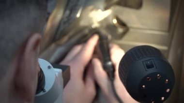 Mühendis, mikroskop kullanarak fabrikadaki döküm için metal kalıbın doğru ayarlarını kontrol ediyor.