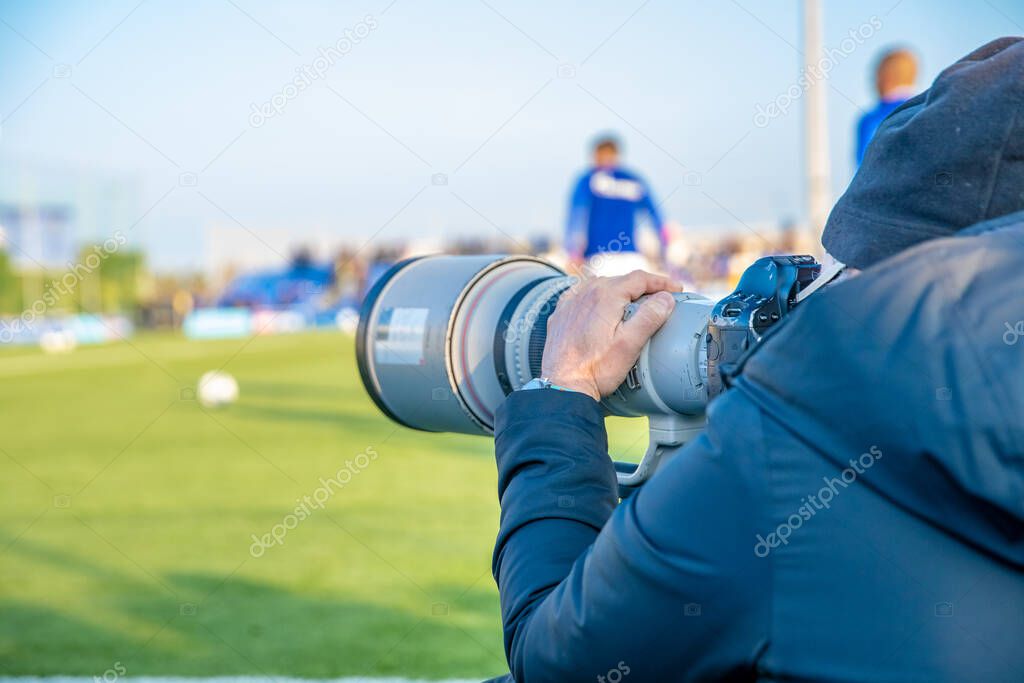 photoreporter with telephoto lens on a football match