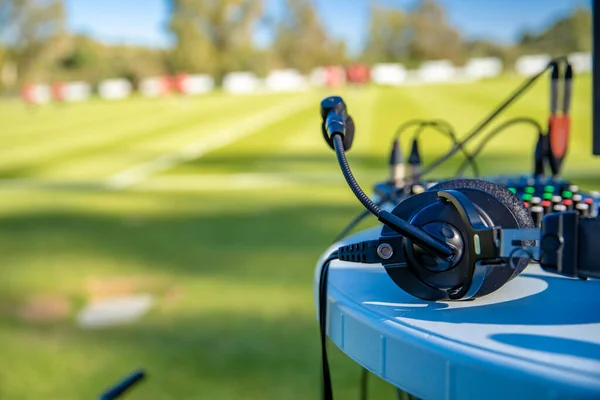 Headset komentator di meja sebelah lapangan sepak bola. stream untuk televisi dan radio — Stok Foto