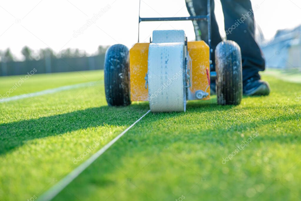 Lining a football pitch using white paint on grass