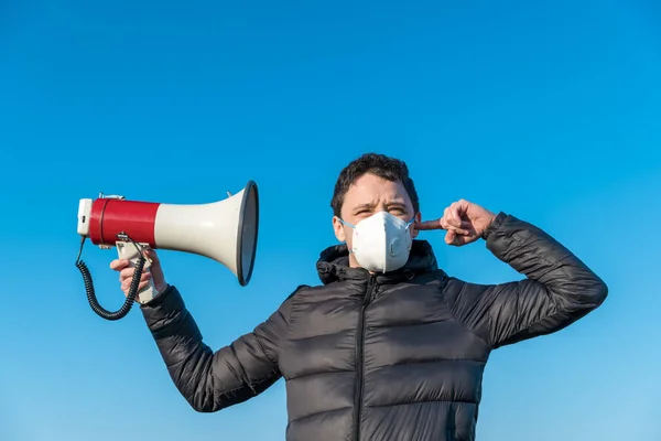 Um megafone como símbolo de espalhar uma enorme quantidade de informação sobre coronavírus. Proteção respiratória e filtragem de informações — Fotografia de Stock