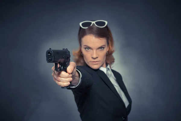 Portrait of woman with gun on blue background — Stock Photo, Image