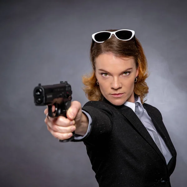 Retrato de mujer con pistola sobre fondo gris —  Fotos de Stock