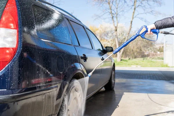 Lavaggio manuale dell'auto spruzzando acqua trattata ad alta pressione. self-service veloce autolavaggio — Foto Stock