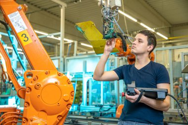Bir üretim mühendisi tarafından yeni bir ürün için robot kollarının programlanması