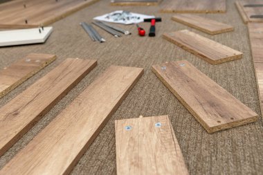 Bir tornavida ve çekiç kullanarak mağazada alışveriş yaptıktan sonra evde mobilya monte etmek