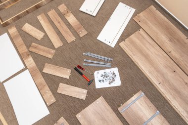 Bir tornavida ve çekiç kullanarak mağazada alışveriş yaptıktan sonra evde mobilya monte etmek