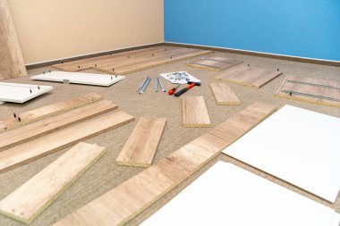 Bir tornavida ve çekiç kullanarak mağazada alışveriş yaptıktan sonra evde mobilya monte etmek