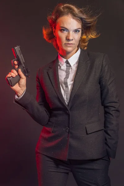 Portrait of woman with gun on brown background — Stock Photo, Image