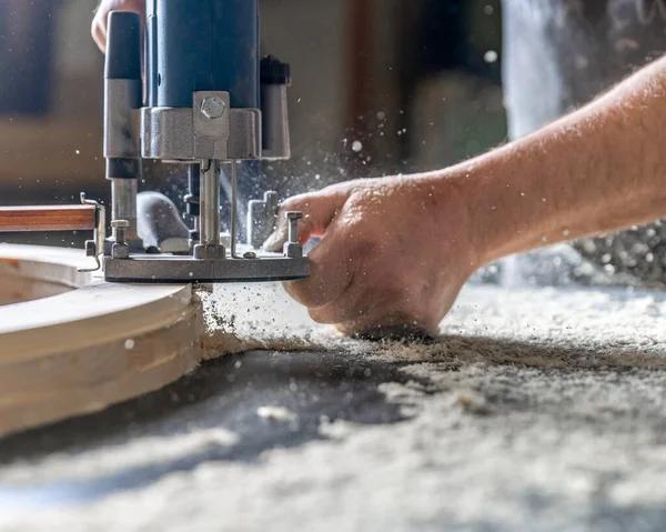 Fresatura del legno in falegnameria con frese meccaniche manuali. Segatura volante nell'aria — Foto Stock