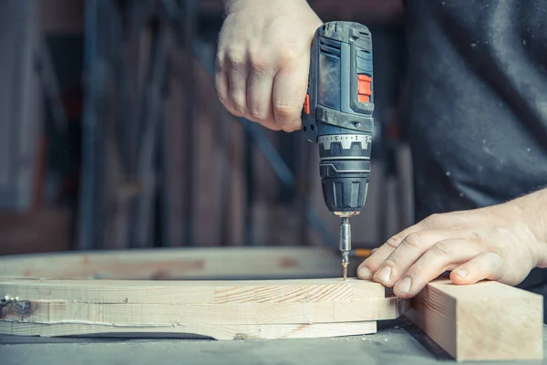 Screwing wooden furniture in a joinery using an electric drill bit — Stock Photo, Image