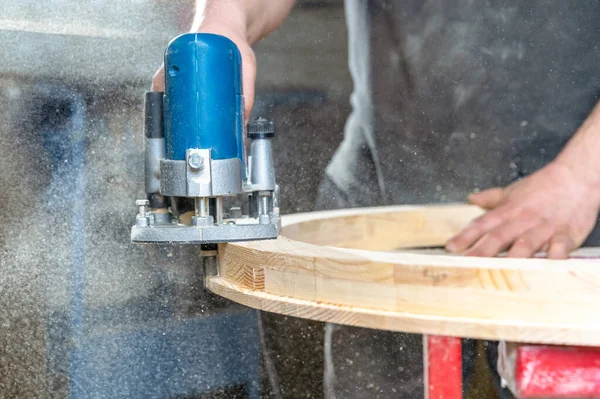 Φρεζάρισμα του στρογγυλού ξύλινου παραθύρου με χρήση χειρολαβών ηλεκτρικών κοπτικών σε κουφώματα — Φωτογραφία Αρχείου