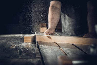 Marangoz dairesel testereyle tahta keser.