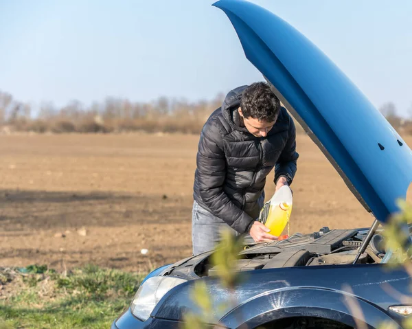 L'uomo riempie il liquido lavavetri — Foto Stock