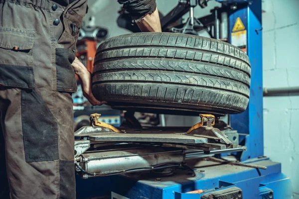 Bir teknisyen, lastik servisinde özel bir makinede tekerlek değiştiriyor. — Stok fotoğraf