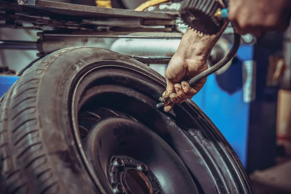 Presurizar el neumático del coche en un servicio de neumáticos — Foto de Stock