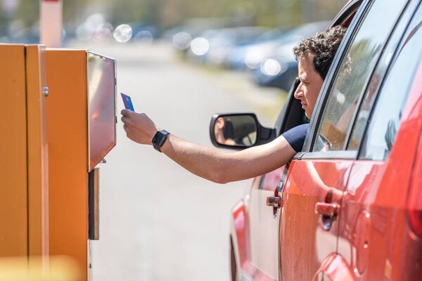 man pays by credit card parking in the parking meter