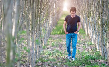Genç bir adam ormanda yürüyor. Boşluğu kopyala