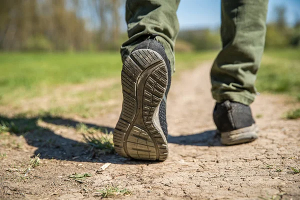 Ένας τουρίστας περπατά σε ένα χωματόδρομο. κλείσιμο των ποδιών και των υποδημάτων — Φωτογραφία Αρχείου