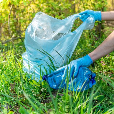 Plastik atık ile gezegenin küresel kirliliği. Gönüllüler atık toplayarak ormanları ve çayırları temizleyerek ekolojiye yardım ediyor