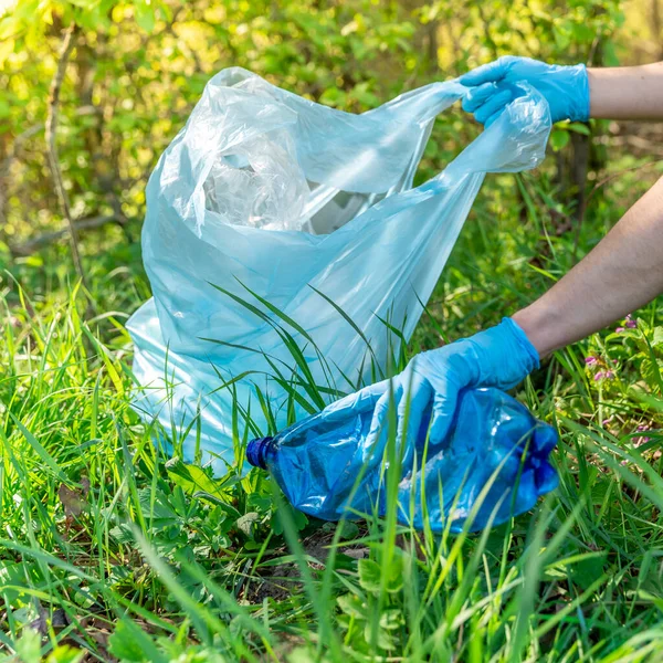 塑料废物对地球的全球污染。志愿人员通过清理森林和草地以及收集废物来帮助生态 — 图库照片